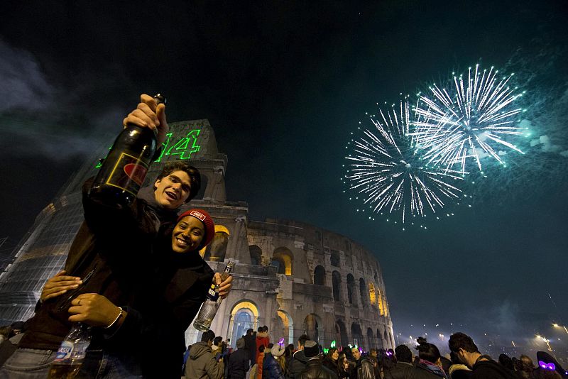 Una pareja posa durante el espectáculo de fuegos artificiales en el Coliseo