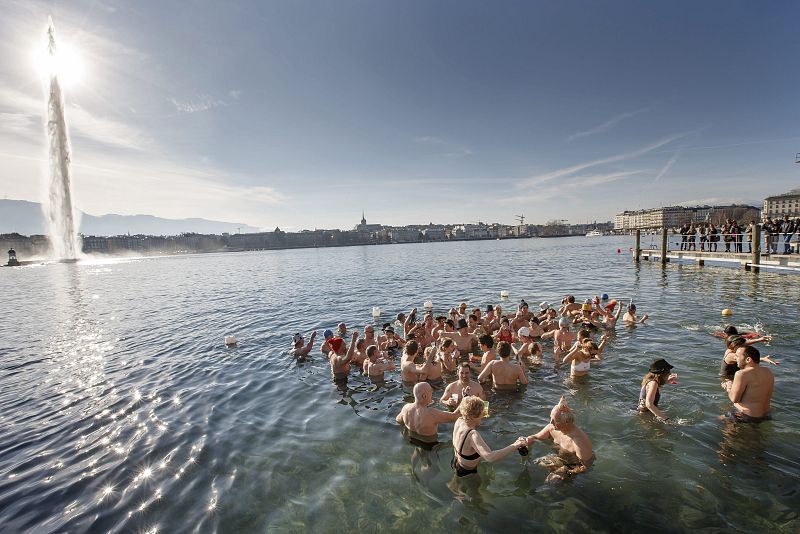 Cerca de 60 personas brindan con champán en las frías aguas del lago de Ginebra durante el tradicional baño de Año Nuevo