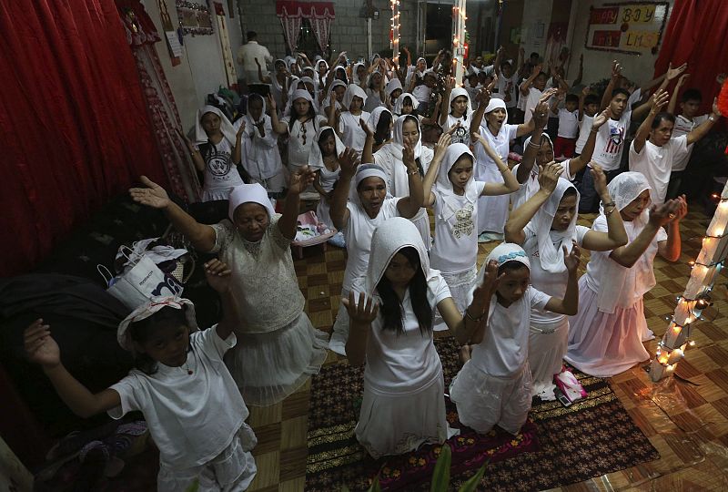 Filipinos rezan durante un ritual de celebración del Año Nuevo en la región de Sierra Madre