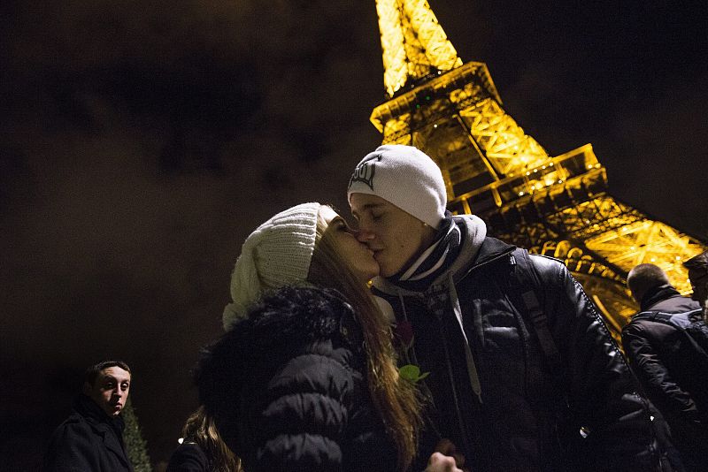 Una pareja se besa frente a la Torre Eiffel para celebrar el comienzo del Año Nuevo 2014