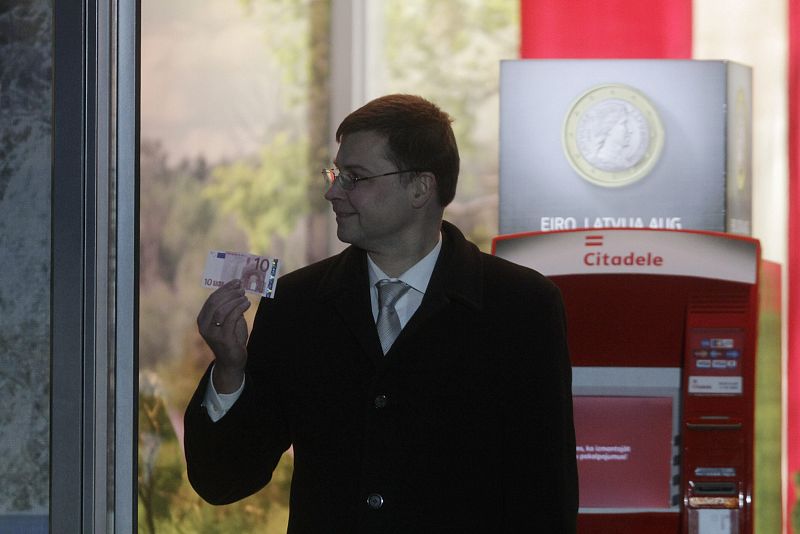 El primer ministro letón, Valdis Dombrovskis, sostiene un billete de 10 euros