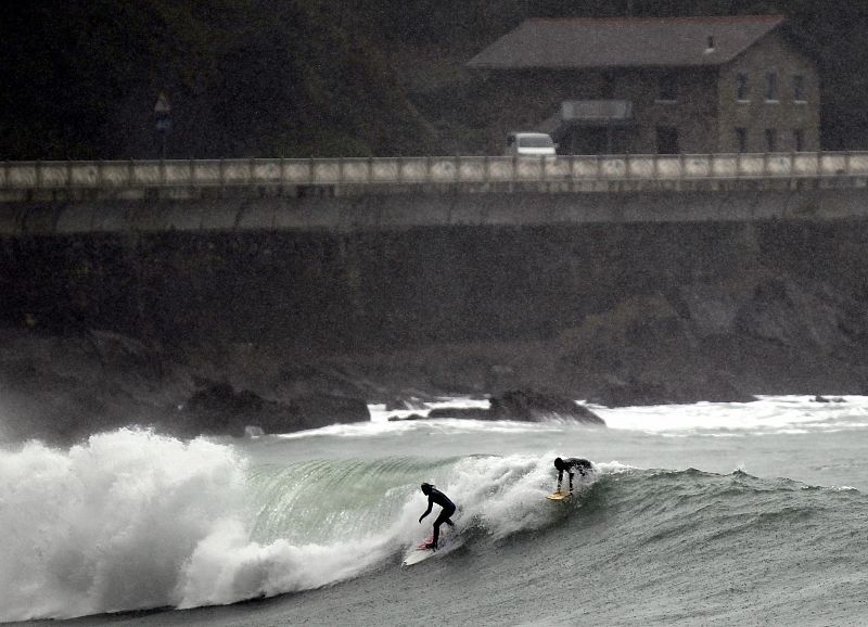 Dos surfistas aprovechan las olas en Zumaia (Gipuzkoa).