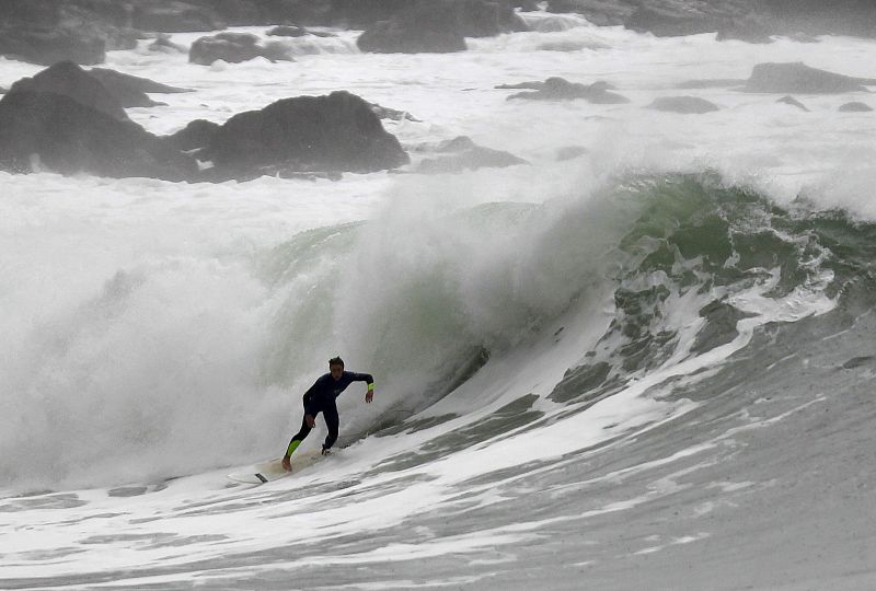 Un surfista aprovecha las olas en la localidad guipuzcoana de Zumaia, donde se registran fuertes rachas de viento y abundantes precipitaciones.