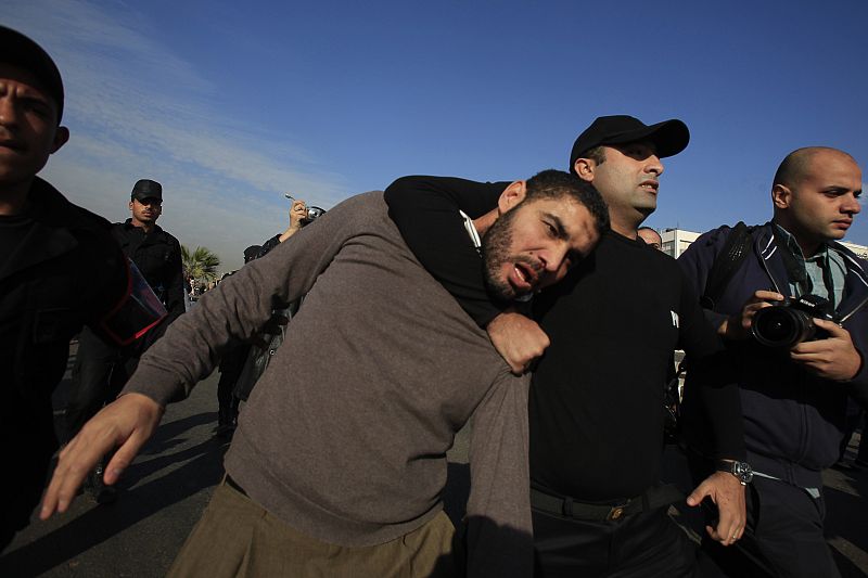 Agentes detienen a un hombre que protestaba delante de la Academia Militar, donde se celebra el juicio