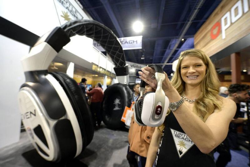 Una mujer sostiene unos auriculares Turtle Beach con conexión inalámbrica