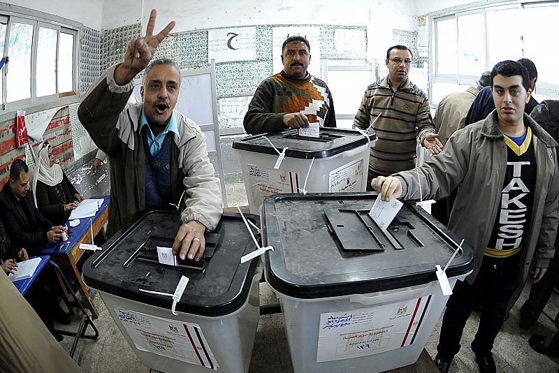 Un egipcio hace la señal de la victoria tras depositar su voto en un colegio electoral de Alejandría.