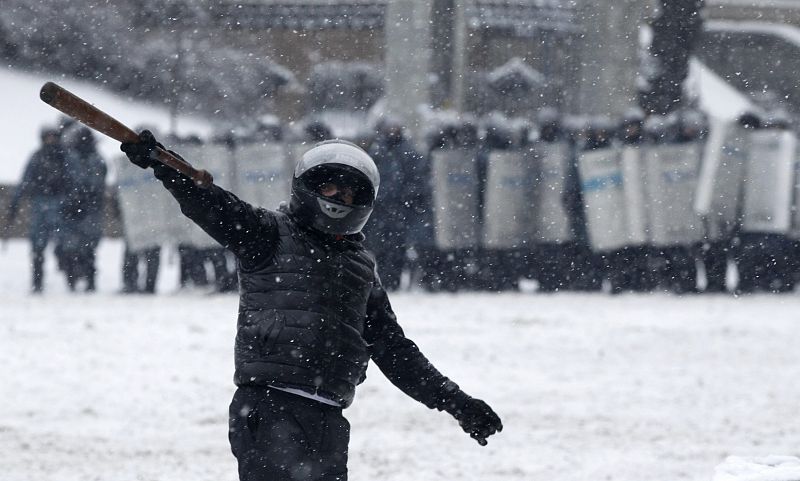 Un manifestante ucraniano frente a los antidisturbios en Kiev. Los opositores resisten en la Plaza de la Independencia los intentos de desalojo.