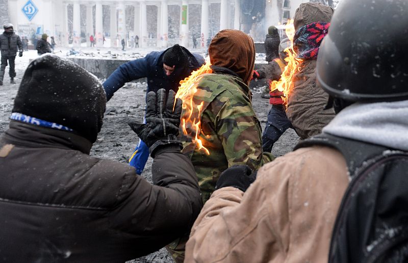 La chaqueta de un manifestante arde durante los enfrentamientos con la policía en Kiev.