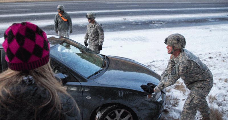 El ejército ayuda a una mujer a sacar su coche atrapado en la nieve.