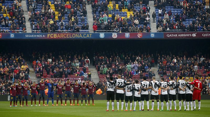 Barcelona and Valencia players stand during a minute of silence for former Spain coach Luis Aragones at Camp Nou stadium in Barcelona