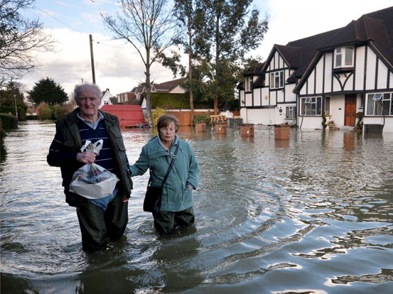 Los residentes de Wraysbury en Berkshire, avanzan a través del agua de la inundación.