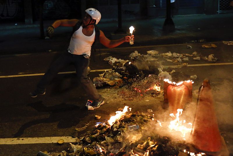 Un manifestante lanza un cóctel molotv durante las protestas en Caracas.