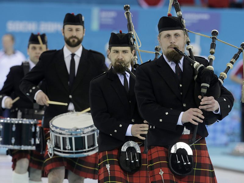 Musicians play bagpipes before the start of the men's curling round robin game at the 2014 Sochi Winter Olympics at the Ice Cube Curling Center in Rosa Khutor