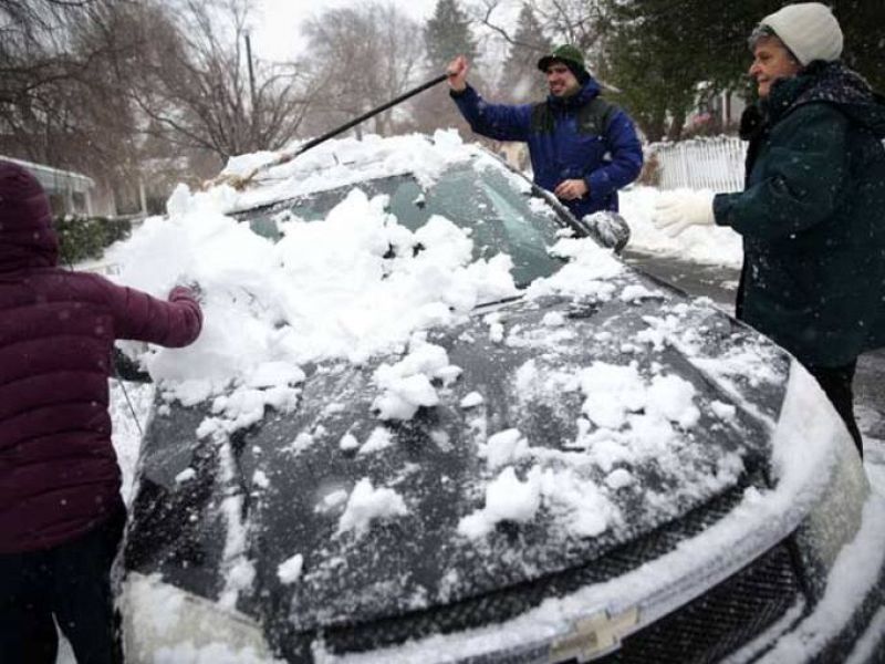 Un grupo de vecinos retiran la nieve acumulada sobre un coche en Warrenton, Virgina.