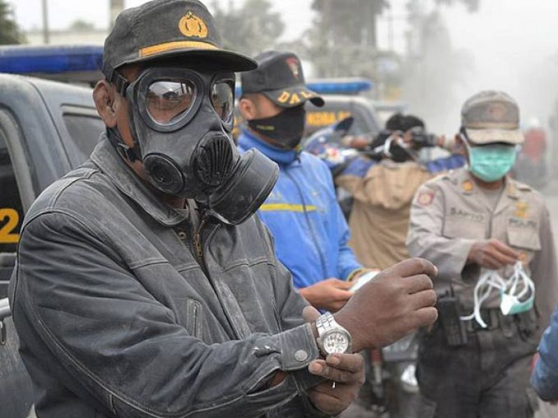 La Policía distribuye máscaras a los habitantes de Malang, en la provincia de Java Oriental, para protegerse de las cenizas volcánicas
