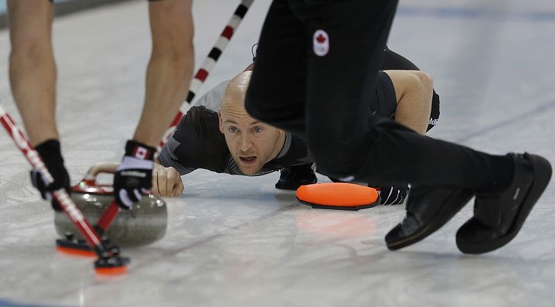Canada's vice Ryan Fry looks down the sheet after delivering a stone during their men's curling round robin game against Norway at the 2014 Sochi Winter Olympics