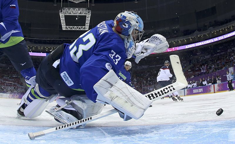 Slovenia's goalie Robert Kristan makes a save on Slovakia during the first period of their men's preliminary round ice hockey game at the 2014 Sochi Winter Olympic Games