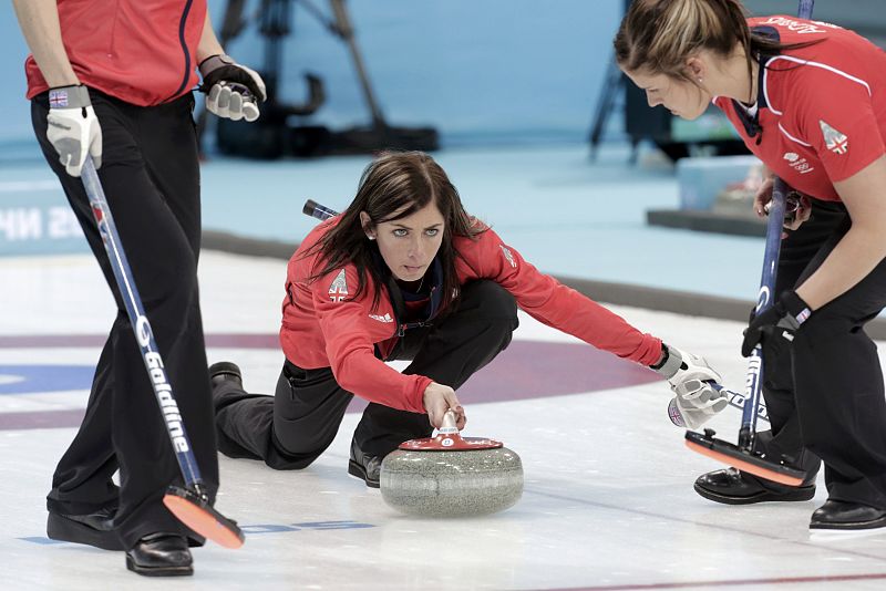 Britain's skip Muirhead delivers a shot as second Adams watches to sweep ahead of it during their women's curling round robin game against South Korea at the 2014 Sochi Olympics
