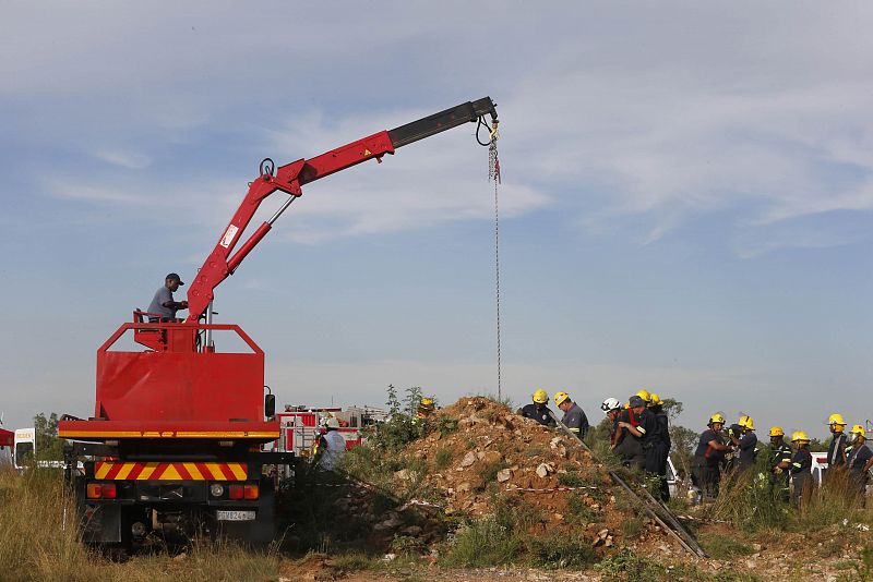 Los equipos de rescate utilizan una grúa para retirar los escombros.