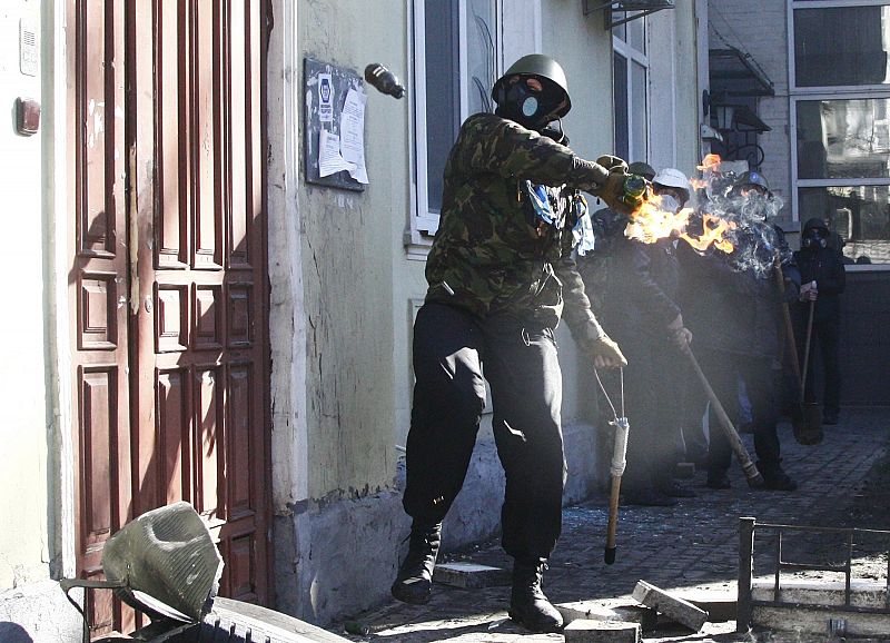 Un manifestante sostiene un cóctel molotov durante los enfrentamientos con los antidisturbios en Kiev