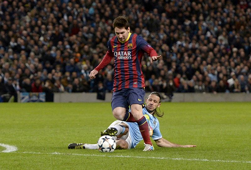 Manchester City's Martin Demichelis fouls Barcelona's Lionel Messi to concede a penalty during their Champions League round of 16 first leg soccer match at the Etihad Stadium in Manchester