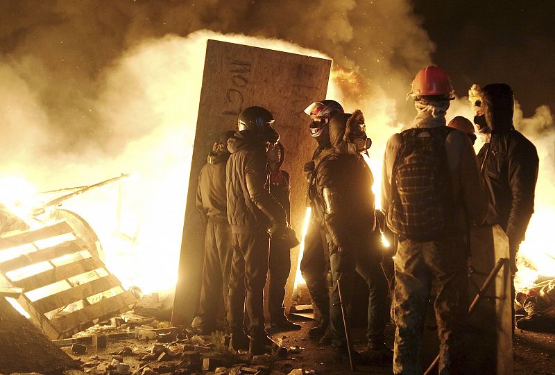 Manifestantes junto a una barricada de fuego en el centro de Kiev, en la madrugada del miércoles