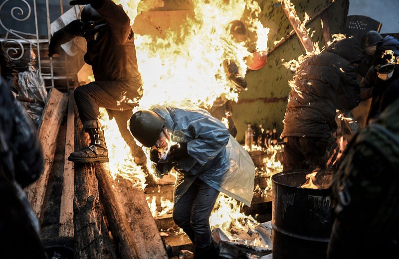 Manifestantes en llamas en la Plaza de la Independencia de Kiev. Los manifestantes mantienen barricadas en llamas para contener a los antidisturbios