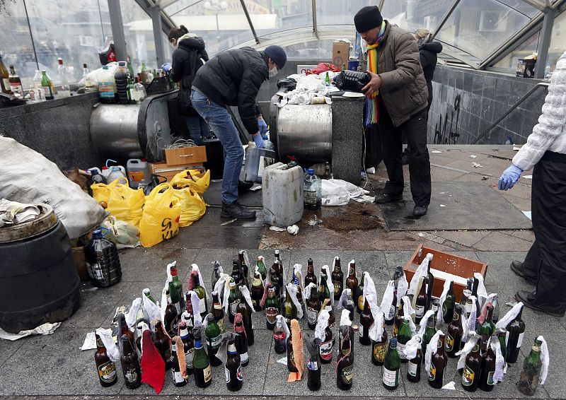 Anti-government protesters prepare Molotov cocktails during clashes with riot police in the Independence Square in Kiev