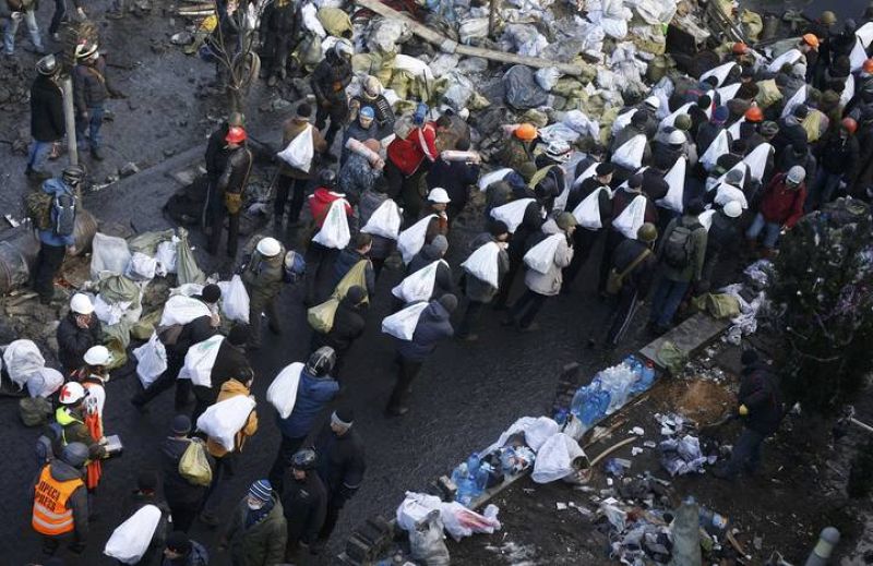 Anti-government protesters carry bags filled with stones to build barricades around the Independence Square during clashes with riot police in Kiev