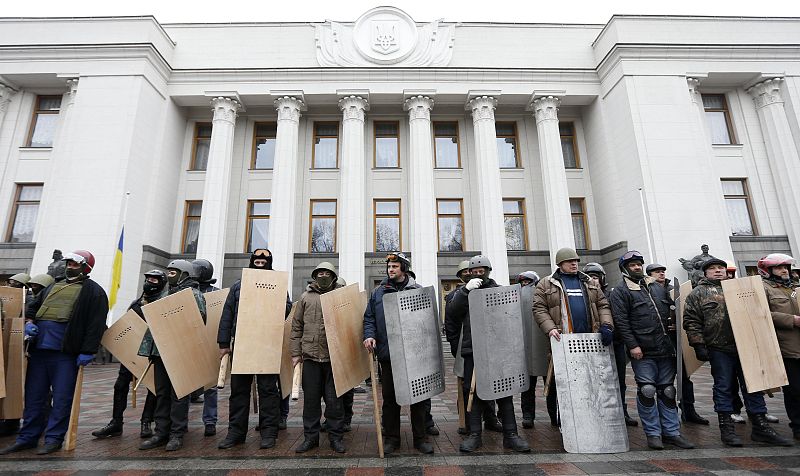 Anti-government protesters hold shields as they guard the Ukrainian Parliament building in Kiev