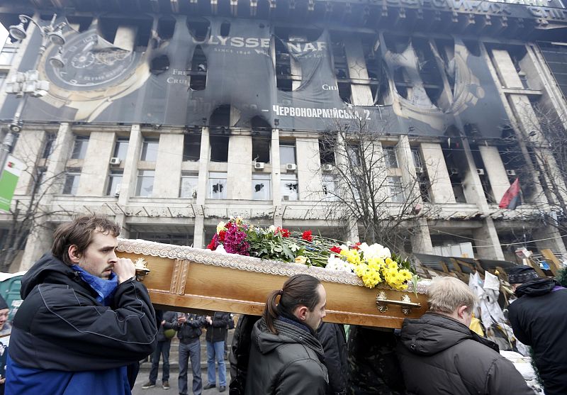 People carry the coffin of one anti-governent protester who was killed after days of violence during a funeral service in Kiev