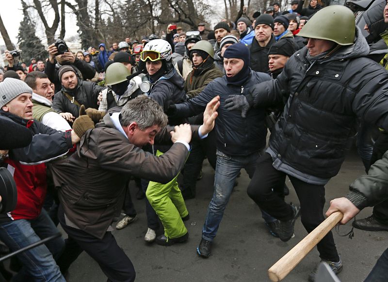 Anti-government protesters attack a deputy of the Party of Regions Vitaly Grushevsky outside the Ukrainian Parliament building in Kiev