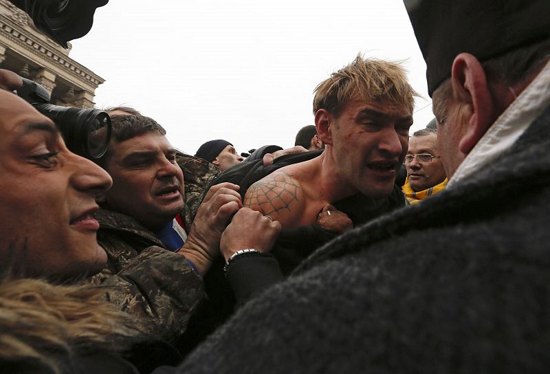 Anti-government protesters attack a man whom they suspect of being a sniper who shot people during recent clashes in central Kiev