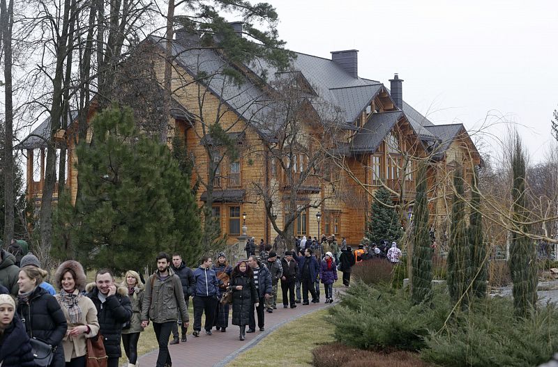 Anti-government protesters and journalists walk on the grounds of the Mezhyhirya residence of Ukraine's President Viktor Yanukovich in the village Novi Petrivtsi outside Kiev