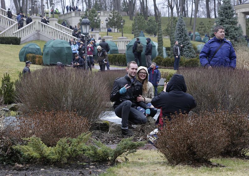 Anti-government protesters and journalists walk on the grounds of the Mezhyhirya residence of Ukraine's President Viktor Yanukovich in the village Novi Petrivtsi outside Kiev