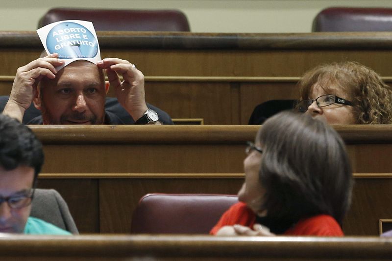 El diputado de la Izquierda Plural Ricardo Sixto Iglesias muestra una pancarta que pide el "aborto libre y gratuito"