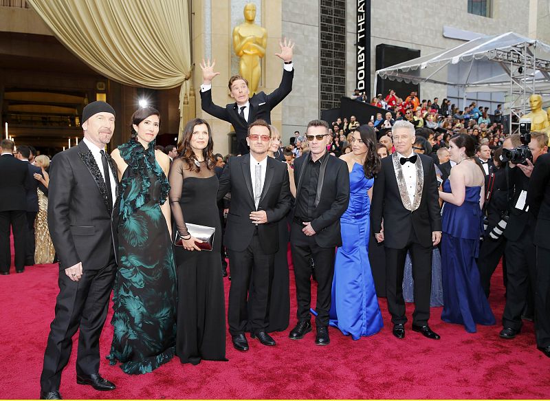 El actor Benedict Cumberbatch salta por detrás de U2 en la alfombra roja de la 86 edición de los Oscar.