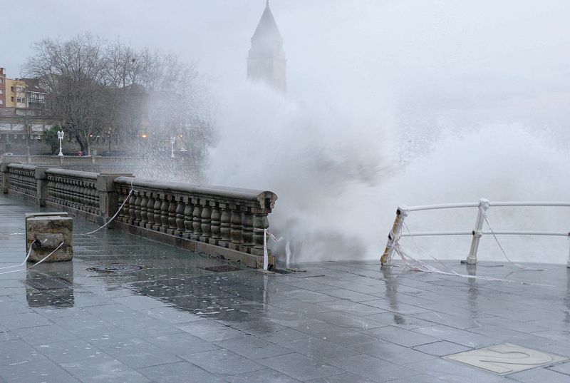 Las olas golpean con fuerza el paseo marítimo de Gijón en el segundo día de temporal en esta semana en la cornisa cantábrica.