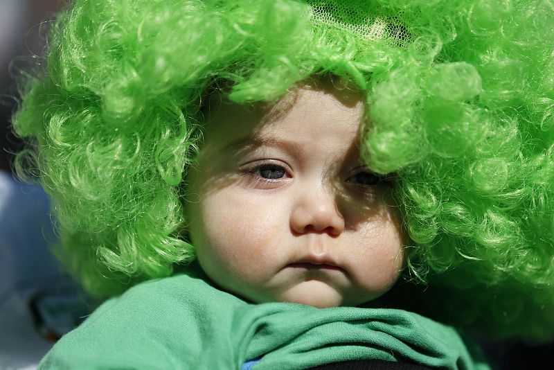 A baby wears a green wig during the St Patrick's Day parade in central London