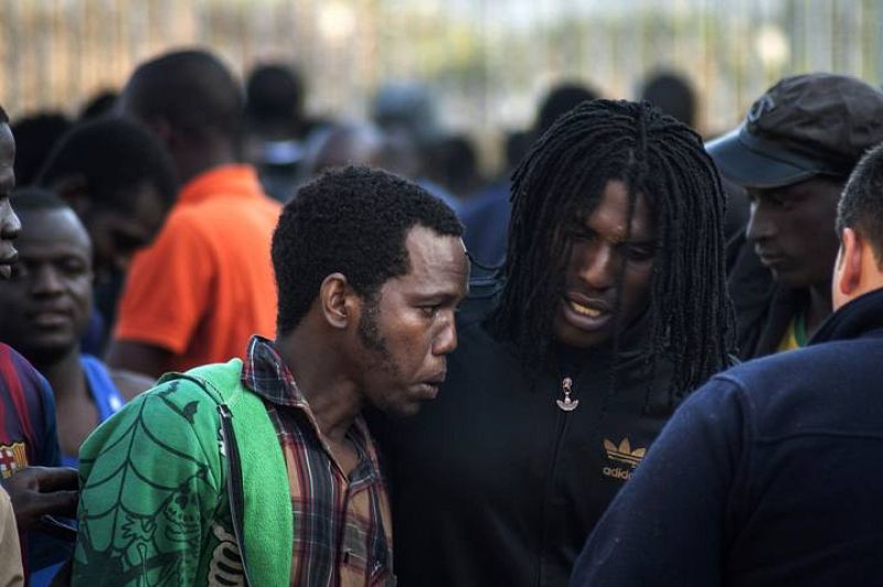 Would-be immigrants talk to one another at a temporary immigrant holding center after crossing the border in Melilla