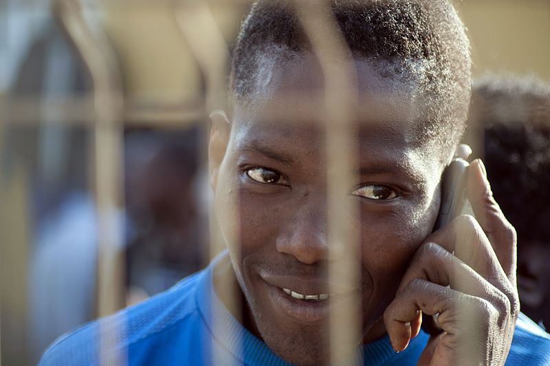 Uno de los inmigrantes que ha logrado saltar la valla de Melilla habla por teléfono en el CETI de Melilla