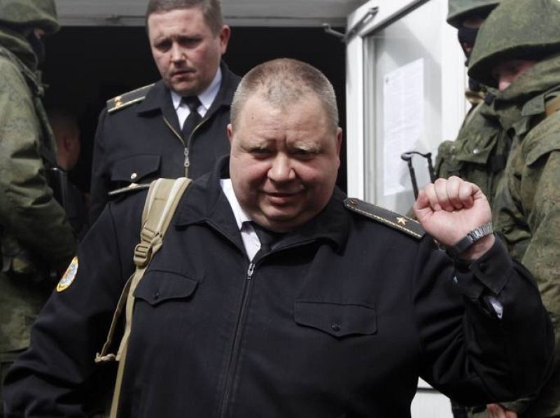 Un marine ucraniano gesticula al abandonar su puesto de trabajo escoltado por prorrusos. 