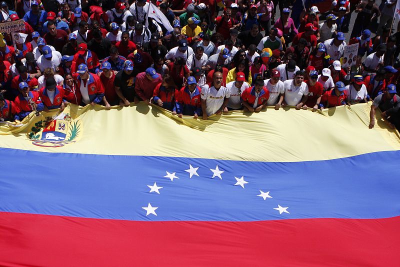 Seguidores de Maduro marchan con una gran bandera de Venezuela