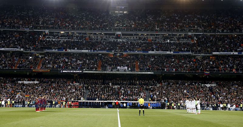 Los jugadores del Barcelona (i) y los del Real Madrid (d), durante el minuto de silencio que han guardado por el fallecimiento del expresidente del Gobierno Adolfo Suárez.