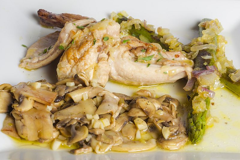 conejo guisado, guarnición de champiñones y espárragos con cebolla confitada