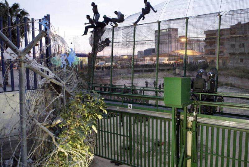 CIENTOS DE INMIGRANTES INTENTAN ENTRAR A MELILLA Y VARIOS SE SUBEN A VALLA