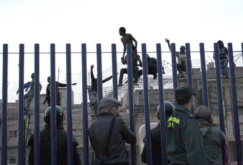 CIENTOS DE INMIGRANTES INTENTAN ENTRAR A MELILLA Y VARIOS SE SUBEN A VALLA