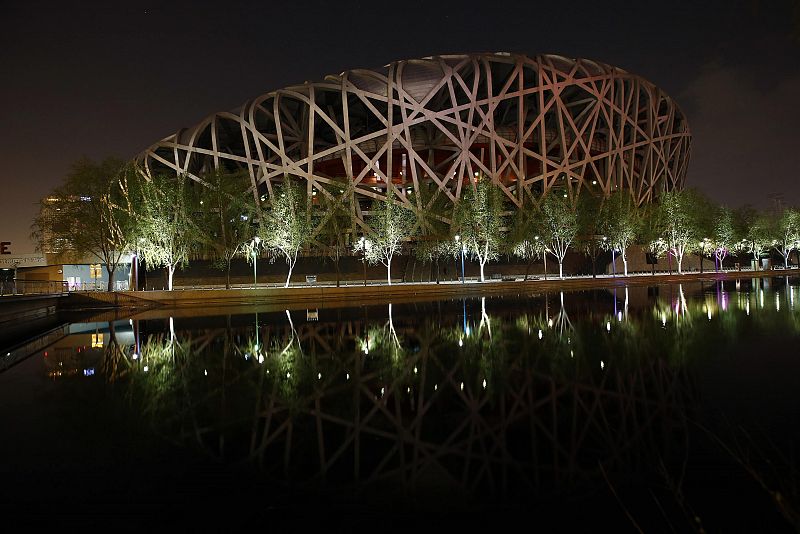 El Estadio Nacional, también conocido como el "Nido de Pájaro", se ve reflejado en un lago durante la 'Hora del Planeta' en el Parque Olímpico en Beijing.