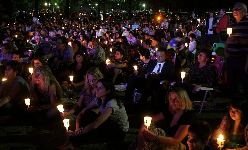 People hold candles outside the Galileo Galilei planetarium to observe Earth Hour in Buenos Aires