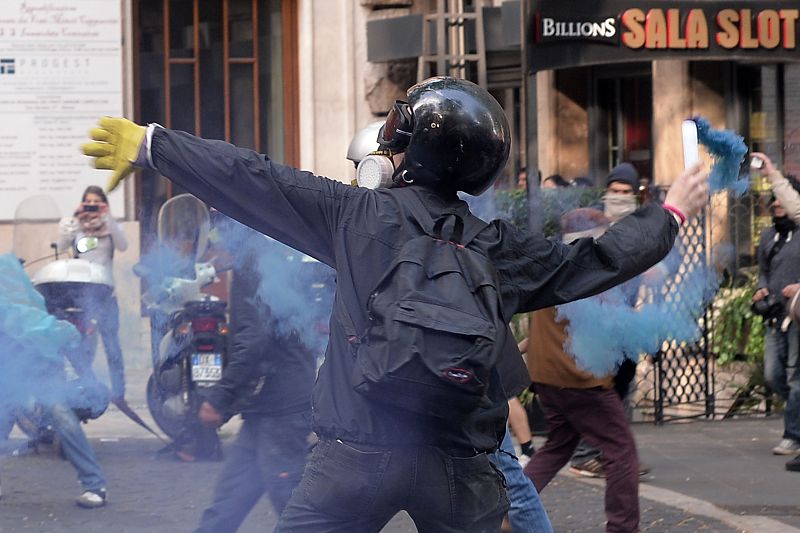 Un hombre lanza un petardo contra la policía tras la manifestación que se ha celebrado en Roma.